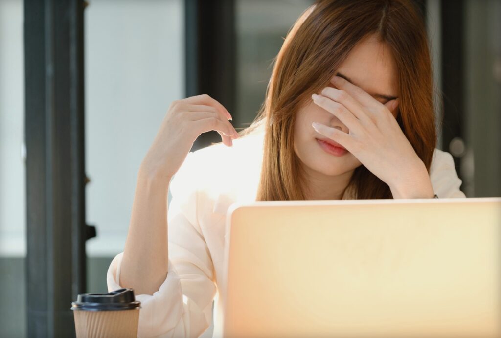パソコンの前で疲れた表情を見せる女性社員