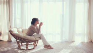 やわらかな光の中で窓辺に座る女性の静かな時間と余白