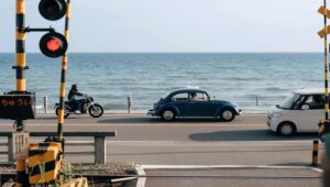 鎌倉の海沿いの踏切で車が行き交う穏やかな風景