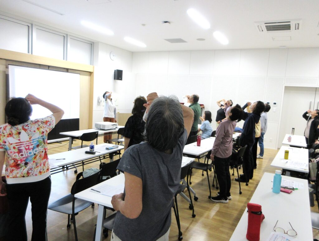 参加者がカンパイのポーズをしながら笑いながら楽しむ「カンパイ笑い」の様子