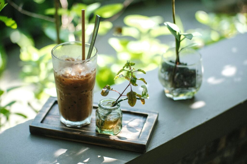 緑に囲まれたカフェでアイスコーヒーを楽しむリラックスタイム