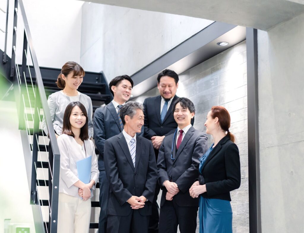 職場で自然な笑顔を交わすメンバー