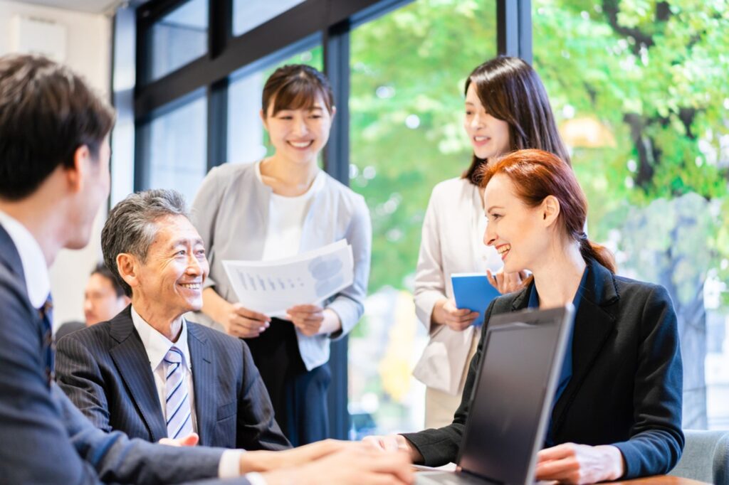 職場で自然な笑顔と会話が生まれている様子