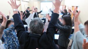 燕三条の笑いのチカラ講座で参加者が両手を上げてワークを体験する様子
